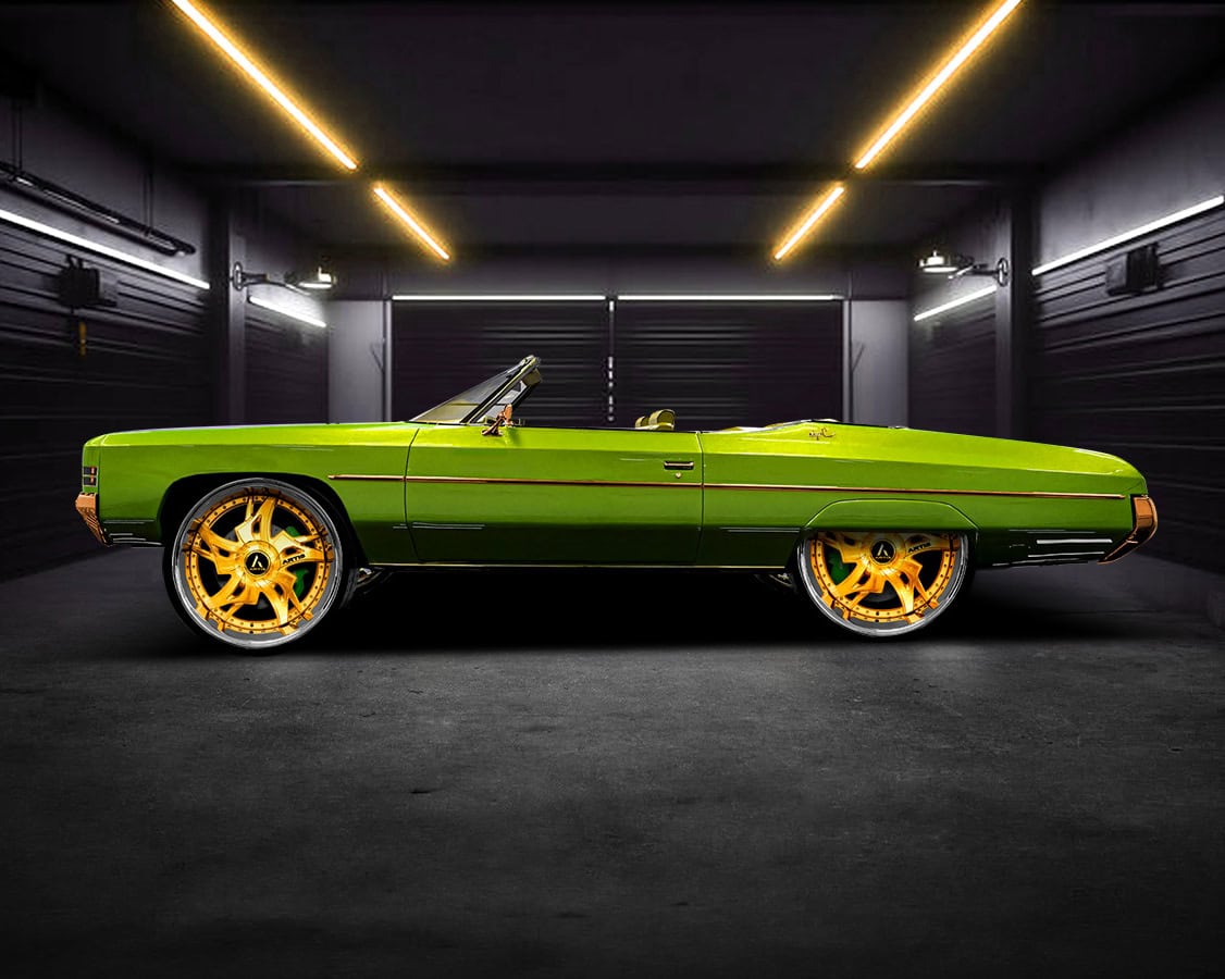 Custom green Laredo-XL convertible with gold wheels in a modern garage.