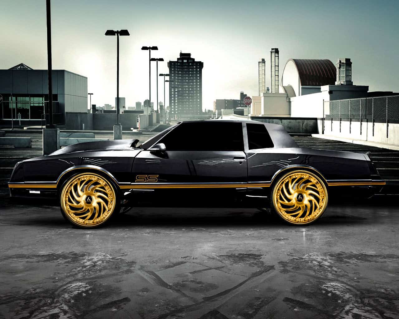 Black Vantage-XL with gold custom wheels on rooftop parking.