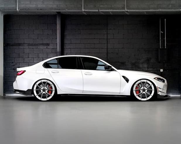 Luxury white sedan with custom Lexani RFL-05 wheels in an industrial setting.