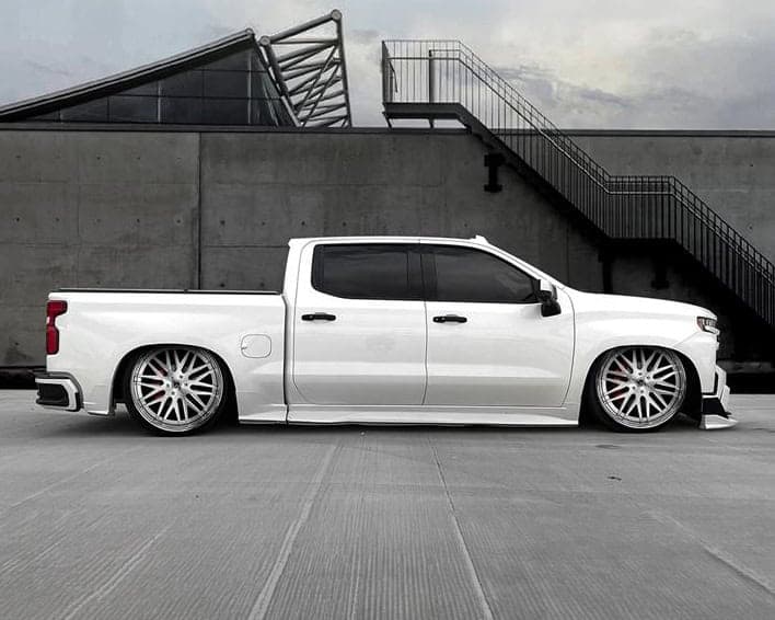 Custom white Lexani Del-Mar pickup truck with lowered suspension and stylish wheels.
