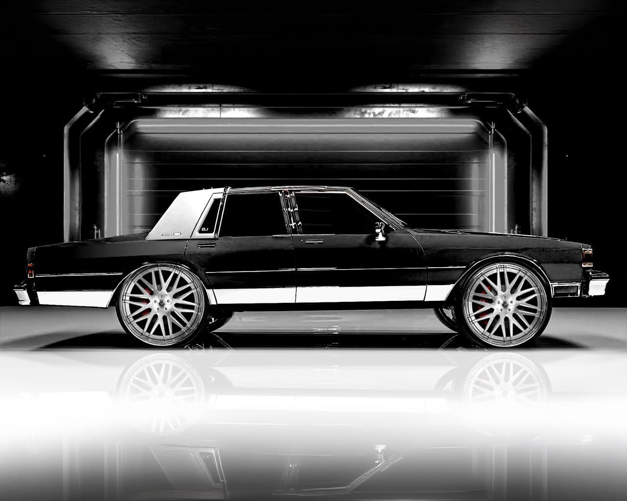 Luxury black custom car with sleek design and custom wheels.