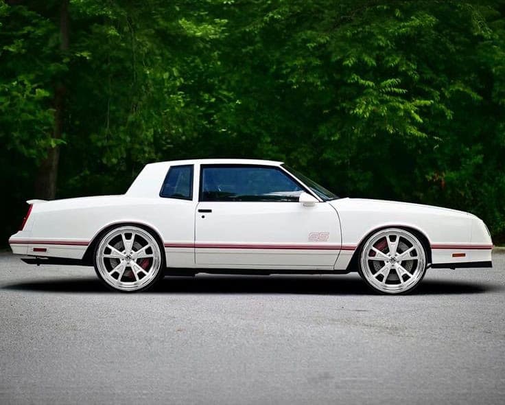 Custom white Lexus Valkyrie with red accents and large wheels.